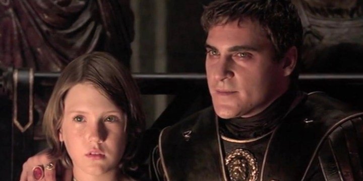 Un hombre se sienta junto a un niño y le pone la mano en el hombro.