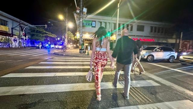 Extranjero acompañado de una joven colombiana en una calle de El Poblado.