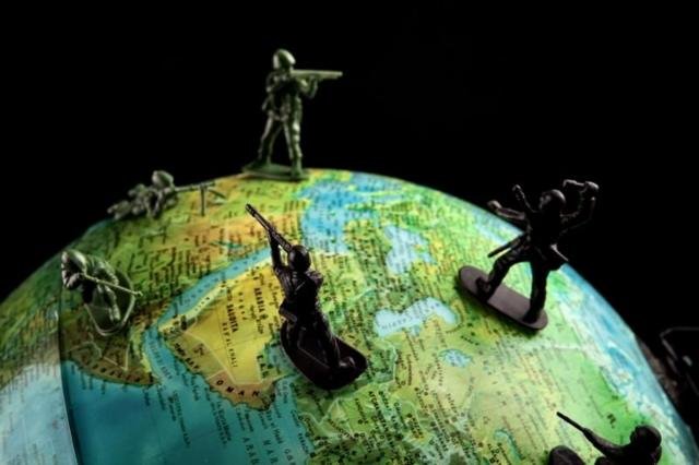 Globo terráqueo con soldados de plomo sobre él.