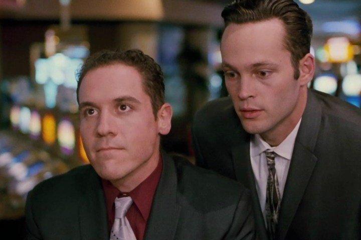 Dos hombres trajeados se sientan y juegan a las cartas.