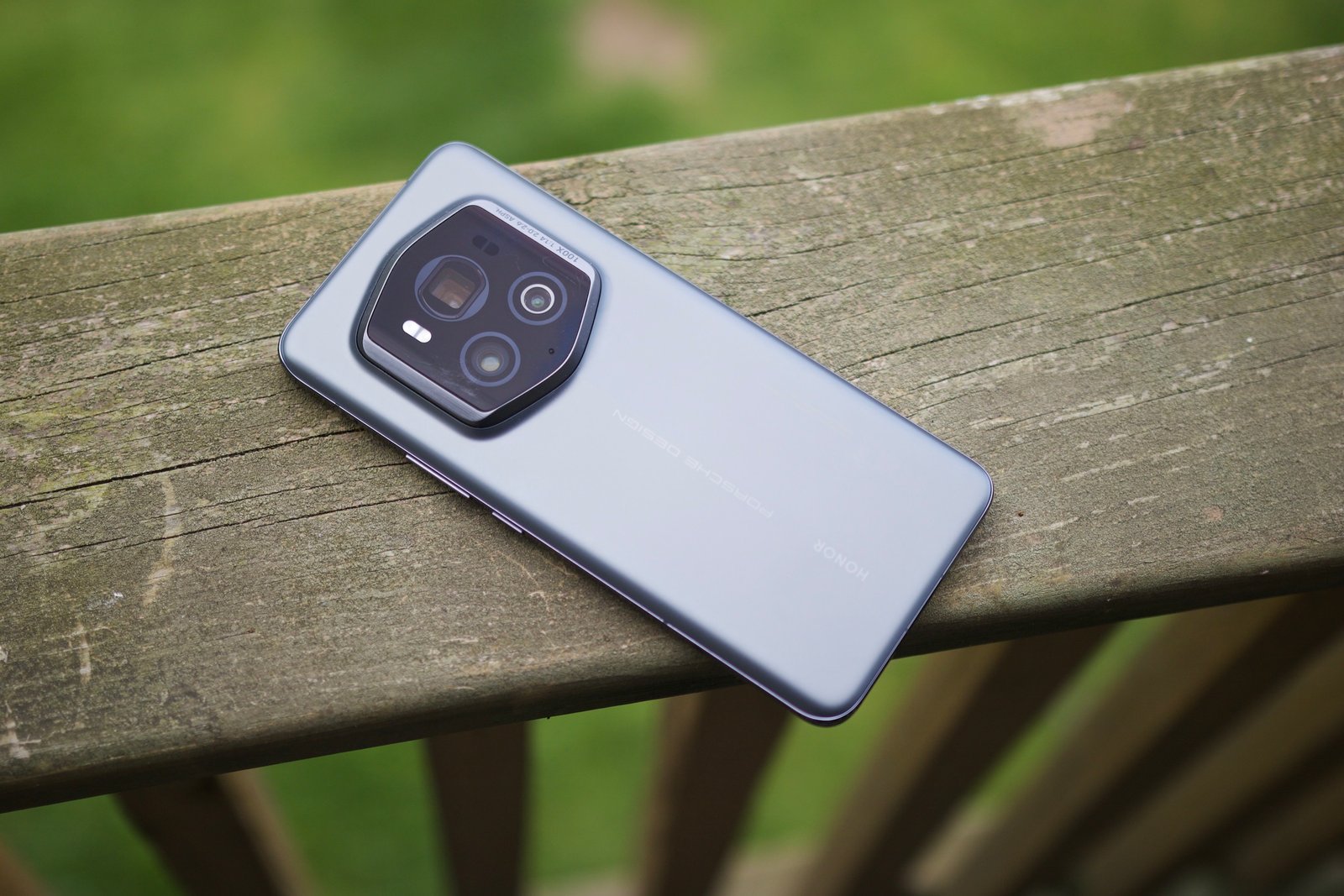 El Honor Magic 6 RSR tumbado boca abajo sobre una barandilla de madera.