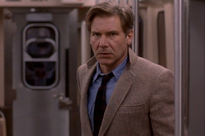 Harrison Ford está de pie en un tren en El fugitivo.