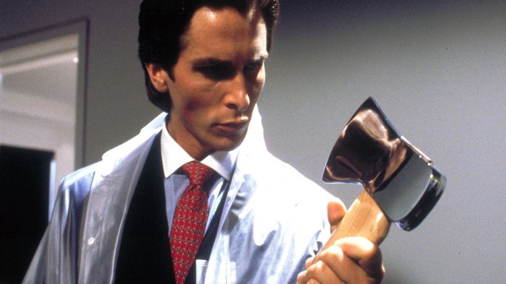 Christian Bale mirando un hacha en American Psycho.