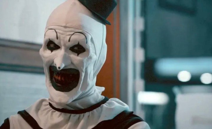 Un payaso malvado sonríe sádicamente.