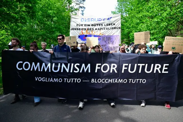 Activistas ambientales marchan frente a una planta deTesla en Gruenheide, al sureste de Berlín, el 11 de mayo de 2024, para protestar contra los planes de la compañía de talar los árboles para ampliar la fábrica.