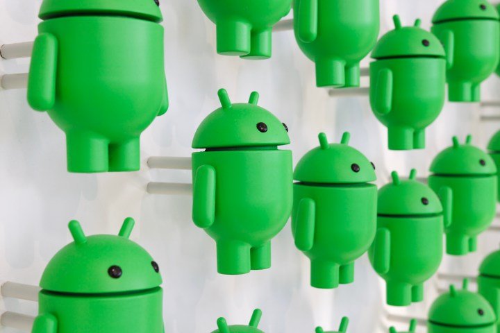 Una foto de muchas figuritas de Android en una pared blanca.