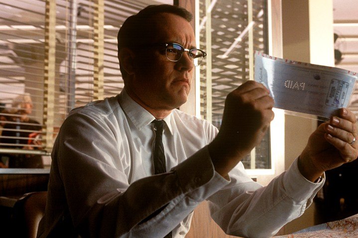 Tom Hanks inspecciona un cheque en Atrápame si puedes.