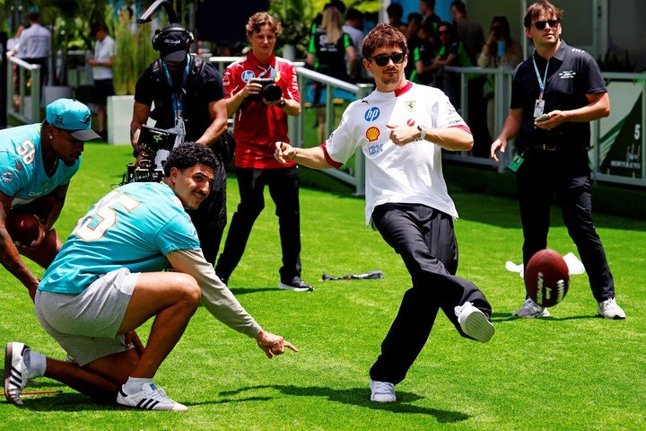 Charles Leclerc patea la pelota de fútbol americano con el jugador de la NFL Jaelan Phillips (Reuter).