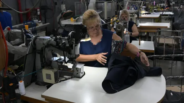 Trabajadoras confeccionan trajes en la fábrica argentina de ropa formal "Confecciones Semana S.A." en Buenos Aires el 10 de febrero de 2026.