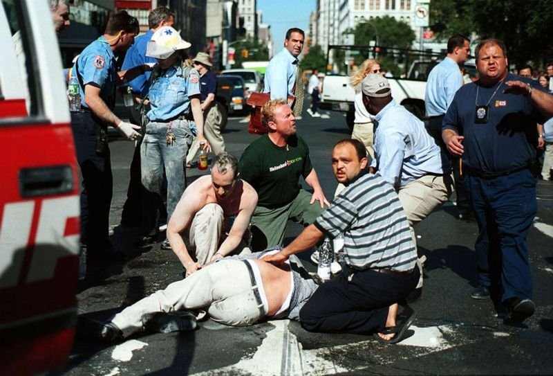 Gente y paramédicos atendiendo a un herido tras el choque de los aviones en las Torres Gemelas de Nueva York